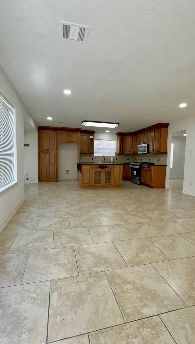 9827 Westminster Dr, Humble, TX 77338 - unfurnished living room featuring a sink, baseboards, and recessed lighting