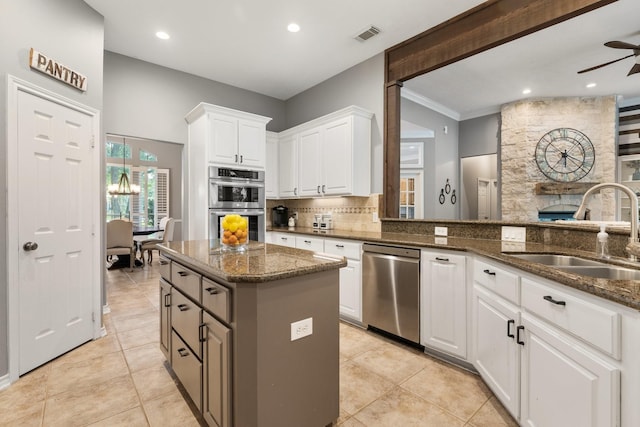 28622 Champions Dr, Magnolia, TX 77355 - kitchen featuring stainless steel appliances, a kitchen island, dark stone counters, decorative backsplash, and a ceiling fan