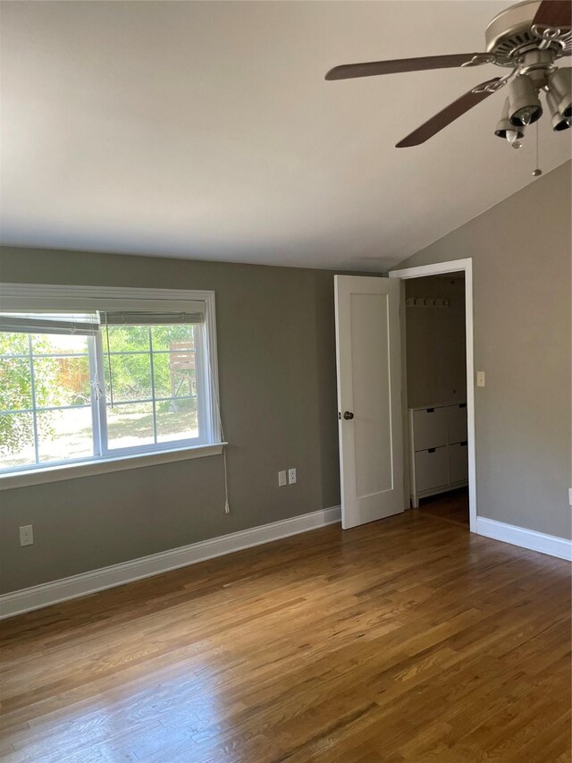 1100 Clayton Ln, Austin, TX 78723 - unfurnished room with a ceiling fan, wood finished floors, lofted ceiling, and baseboards