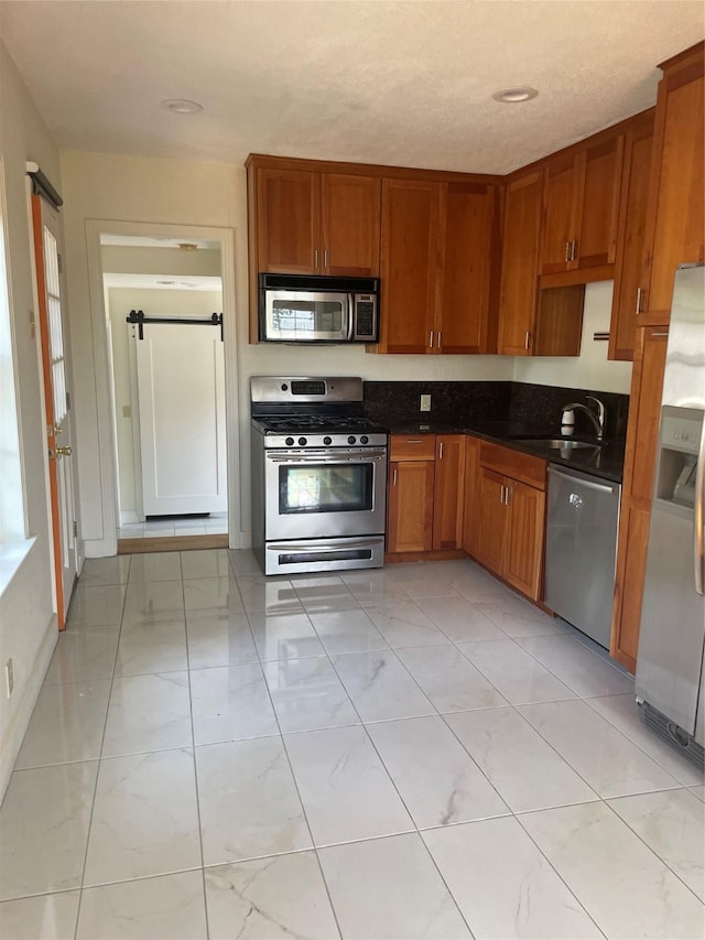 1100 Clayton Ln, Austin, TX 78723 - kitchen with stainless steel appliances, light marble finish floors, brown cabinets, and dark countertops