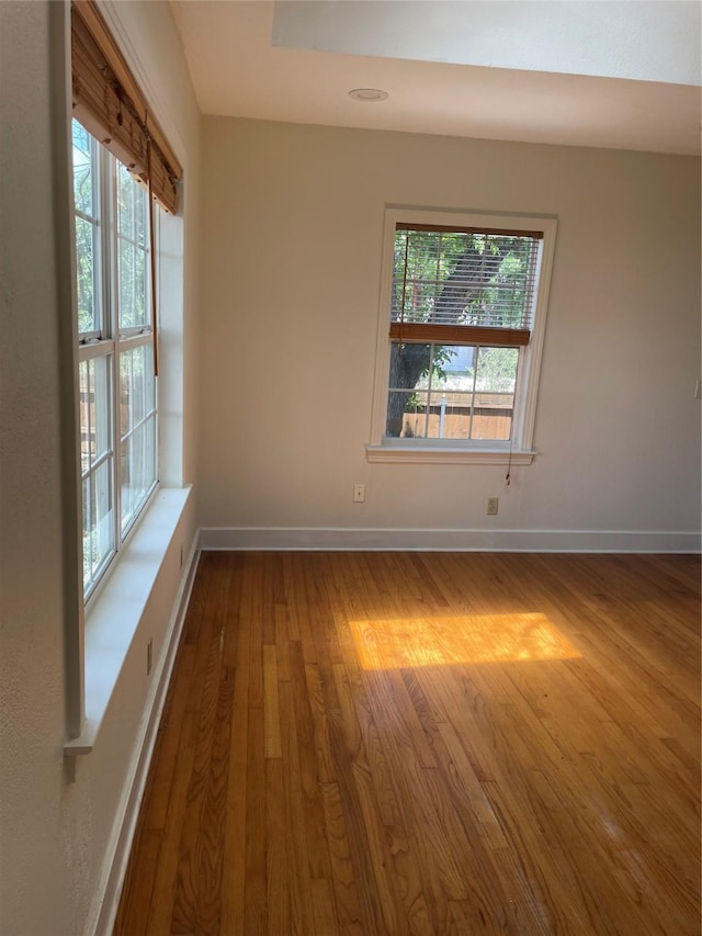1100 Clayton Ln, Austin, TX 78723 - empty room featuring wood finished floors, healthy amount of natural light, and baseboards