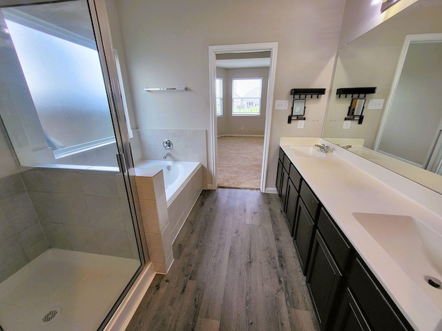 24703 Allori Ct, Katy, TX 77493 - full bath featuring double vanity, wood finished floors, a bath, a stall shower, and baseboards