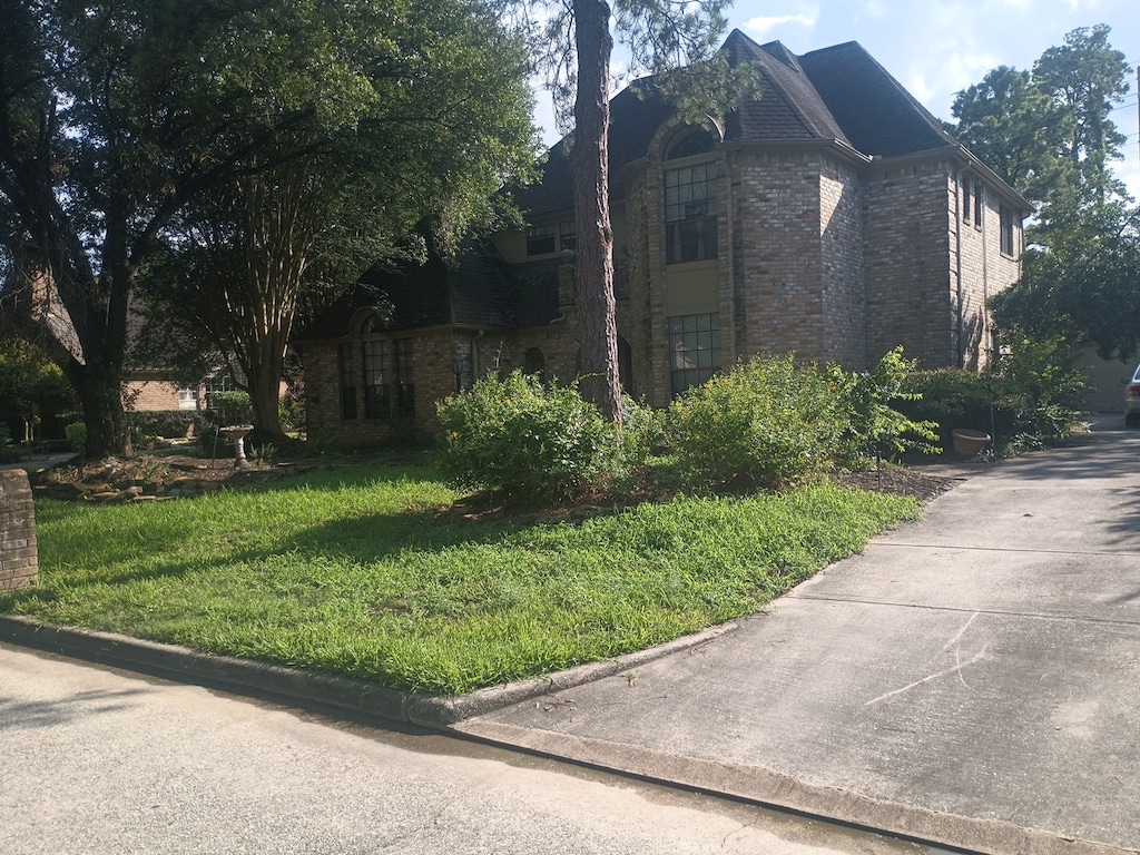 17611 Surreywest Ln, Spring, TX 77379 - view of side of property featuring brick siding and a lawn