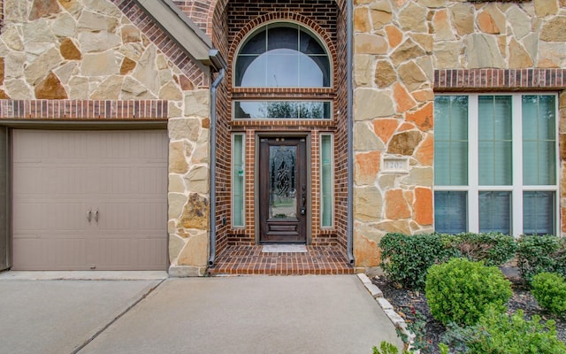 1202 Watercrest Park Ln, Rosenberg, TX 77471 - entrance to property featuring stone siding, concrete driveway, an attached garage, and brick siding