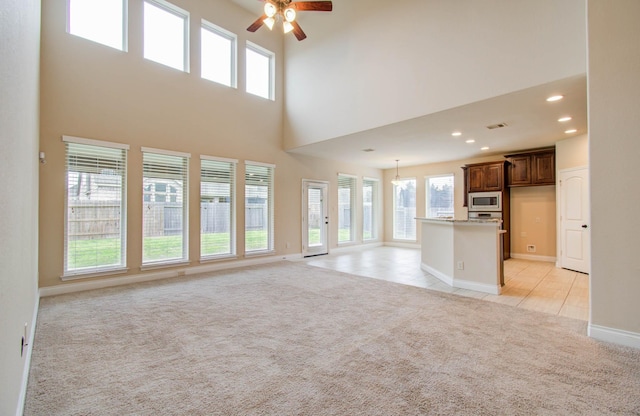 1202 Watercrest Park Ln, Rosenberg, TX 77471 - unfurnished living room featuring light colored carpet, ceiling fan, recessed lighting, baseboards, and a high ceiling