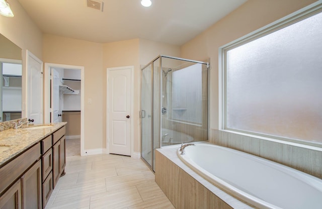 1202 Watercrest Park Ln, Rosenberg, TX 77471 - bathroom with a shower stall, a bath, a walk in closet, double vanity, and baseboards