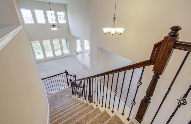 1202 Watercrest Park Ln, Rosenberg, TX 77471 - staircase featuring carpet floors, a towering ceiling, a chandelier, and ceiling fan