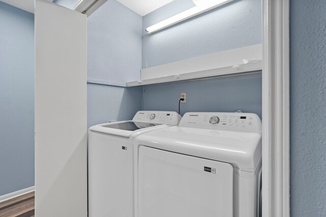 8952 Wilcrest Dr Unit 8952, Houston, TX 77099 - laundry room featuring washing machine and clothes dryer and wood finished floors