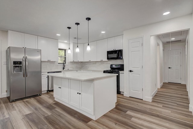 229 Burkett St, Richwood, TX 77531 - kitchen with black appliances, light wood-type flooring, a kitchen island, light countertops, and recessed lighting