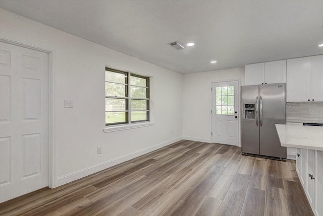 229 Burkett St, Richwood, TX 77531 - kitchen featuring stainless steel refrigerator with ice dispenser, wood finished floors, white cabinets, recessed lighting, and tasteful backsplash