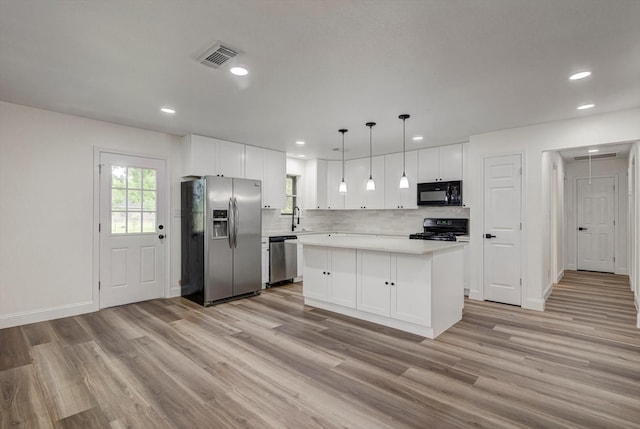 229 Burkett St, Richwood, TX 77531 - kitchen with stainless steel appliances, light wood finished floors, white cabinetry, light countertops, and a center island