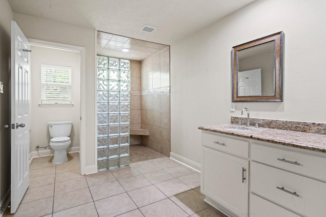 12006 Acorn Oak St, The Woodlands, TX 77380 - bathroom with toilet, vanity, walk in shower, tile patterned floors, and baseboards