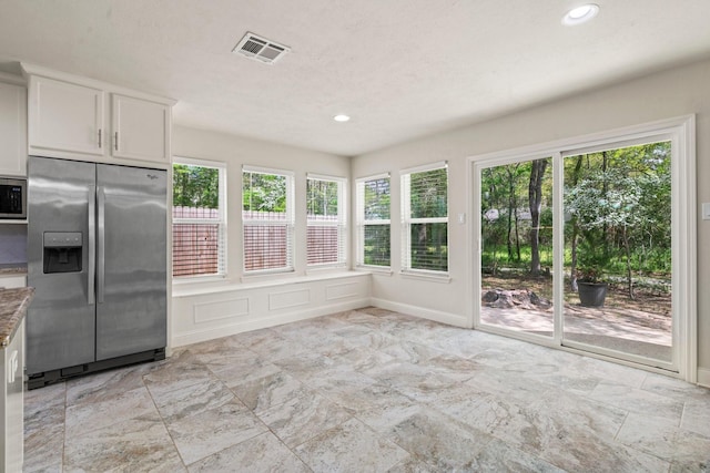12006 Acorn Oak St, The Woodlands, TX 77380 - kitchen featuring appliances with stainless steel finishes, white cabinetry, recessed lighting, light stone countertops, and a decorative wall