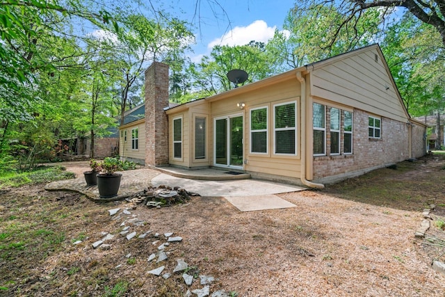 12006 Acorn Oak St, The Woodlands, TX 77380 - back of property featuring a patio area, brick siding, and a chimney