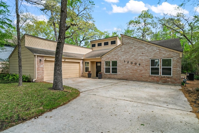 12006 Acorn Oak St, The Woodlands, TX 77380 - mid-century modern home with brick siding, central AC, an attached garage, concrete driveway, and a shingled roof