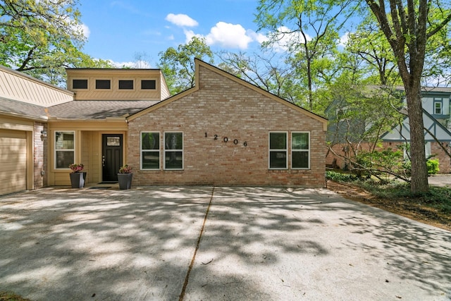 12006 Acorn Oak St, The Woodlands, TX 77380 - back of property featuring brick siding, a garage, and driveway