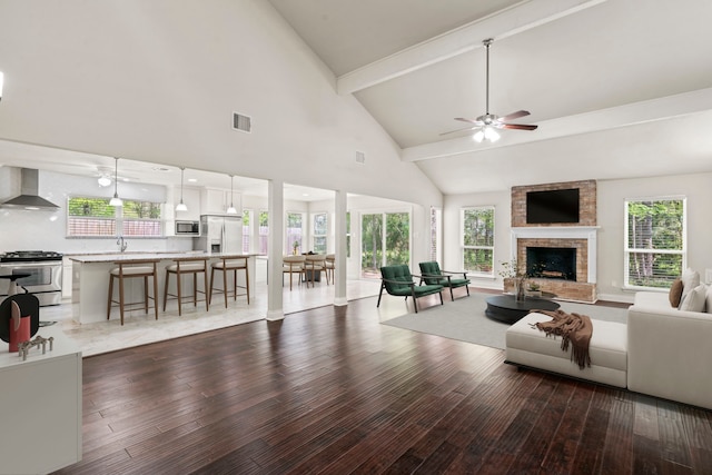 12006 Acorn Oak St, The Woodlands, TX 77380 - living room with a ceiling fan, dark wood finished floors, high vaulted ceiling, a fireplace, and healthy amount of natural light