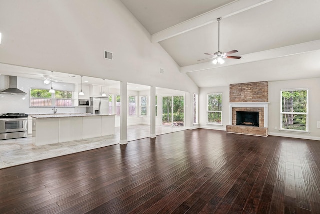 12006 Acorn Oak St, The Woodlands, TX 77380 - unfurnished living room featuring a ceiling fan, light wood finished floors, a sink, high vaulted ceiling, and beamed ceiling
