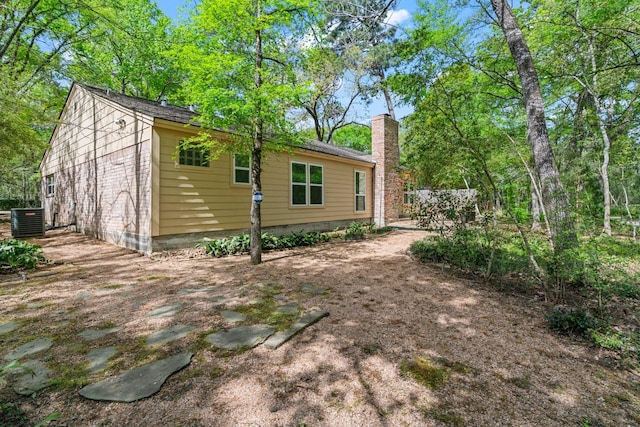 12006 Acorn Oak St, The Woodlands, TX 77380 - view of side of home with cooling unit and a chimney