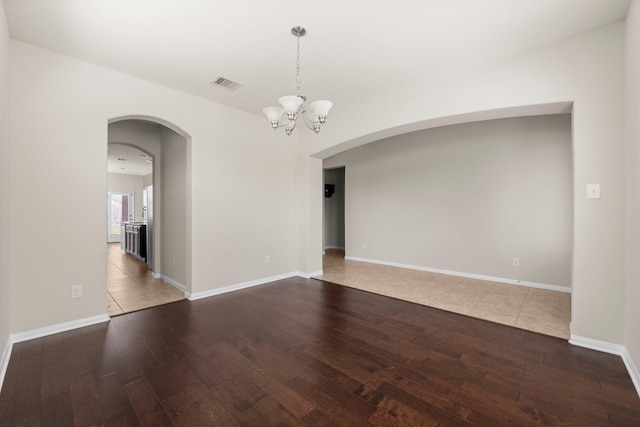 18115 Fernwood Bend Dr, Tomball, TX 77377 - spare room featuring arched walkways, hardwood / wood-style floors, a chandelier, and baseboards