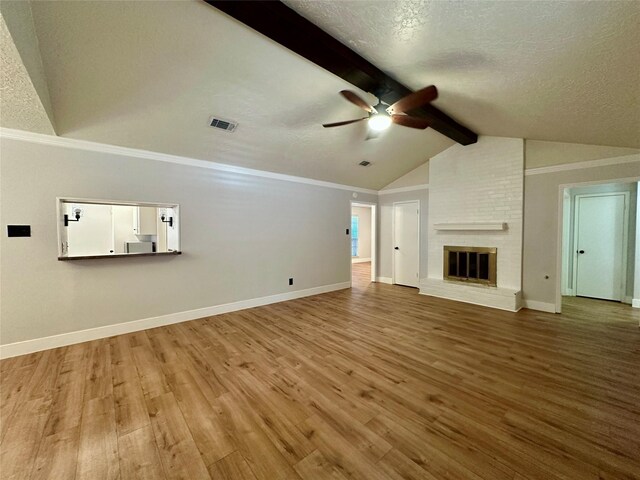 11807 Monticeto Ln, Meadows Place, TX 77477 - unfurnished living room featuring ceiling fan, wood finished floors, baseboards, a brick fireplace, and a textured ceiling
