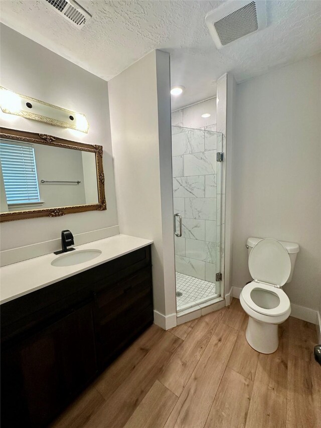 11807 Monticeto Ln, Meadows Place, TX 77477 - bathroom featuring toilet, wood finished floors, vanity, a stall shower, and baseboards