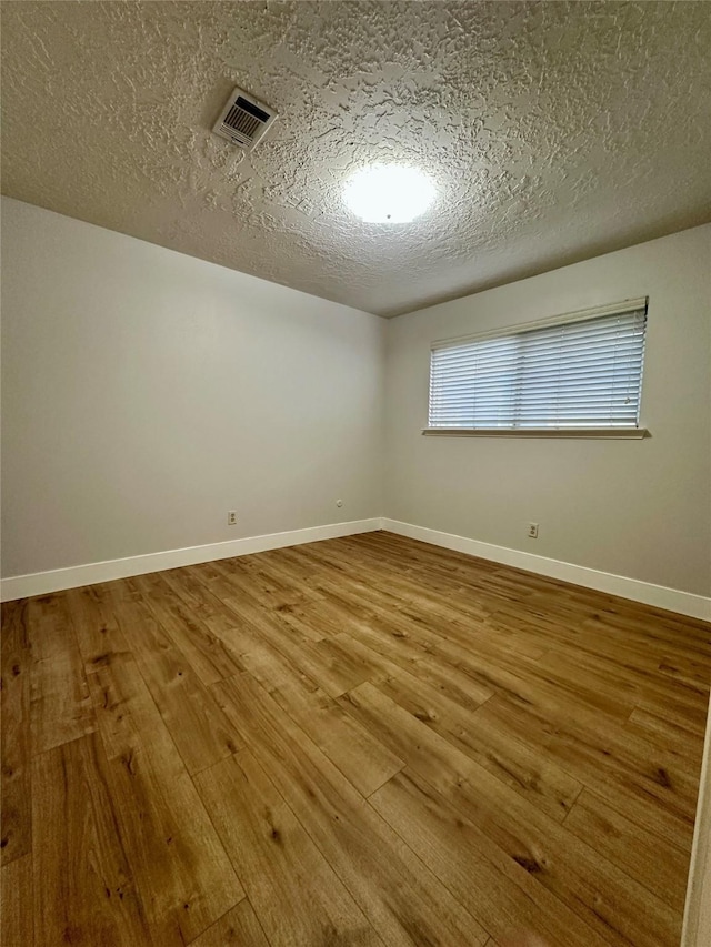 11807 Monticeto Ln, Meadows Place, TX 77477 - spare room featuring hardwood / wood-style floors, a textured ceiling, and baseboards
