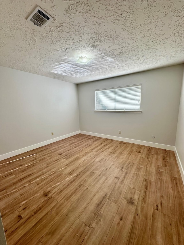 11807 Monticeto Ln, Meadows Place, TX 77477 - empty room with light wood-style flooring, baseboards, and a textured ceiling