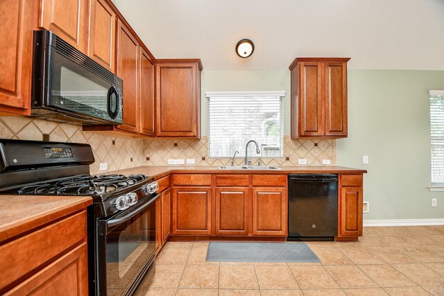 2627 Old River Ln, Richmond, TX 77406 - kitchen with black appliances, a sink, brown cabinets, decorative backsplash, and baseboards