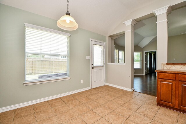 2627 Old River Ln, Richmond, TX 77406 - unfurnished dining area with lofted ceiling, decorative columns, light tile patterned floors, and baseboards