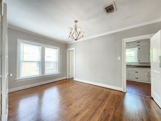 1634 Castle Ct, Houston, TX 77006 - spare room with a chandelier, wood finished floors, ornamental molding, and baseboards
