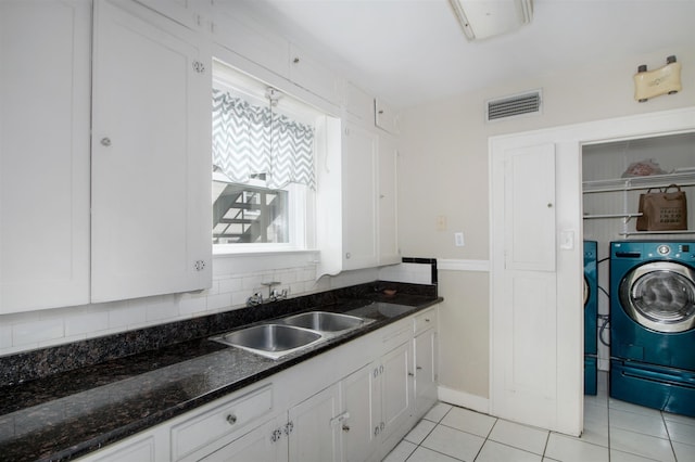 1634 Castle Ct, Houston, TX 77006 - kitchen with washer / dryer, a sink, white cabinetry, and light tile patterned flooring