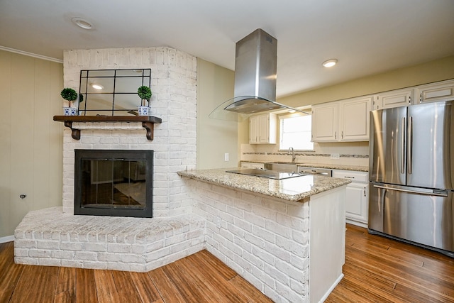2730 Manila Ln, Houston, TX 77043 - kitchen with appliances with stainless steel finishes, island exhaust hood, white cabinets, light stone counters, and dark wood-type flooring