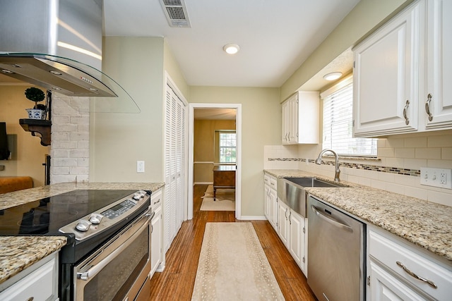 2730 Manila Ln, Houston, TX 77043 - kitchen featuring appliances with stainless steel finishes, ventilation hood, a sink, dark wood finished floors, and white cabinets