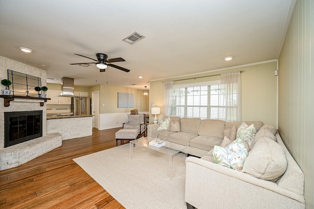 2730 Manila Ln, Houston, TX 77043 - living room with wood finished floors, ceiling fan, a fireplace, ornamental molding, and recessed lighting