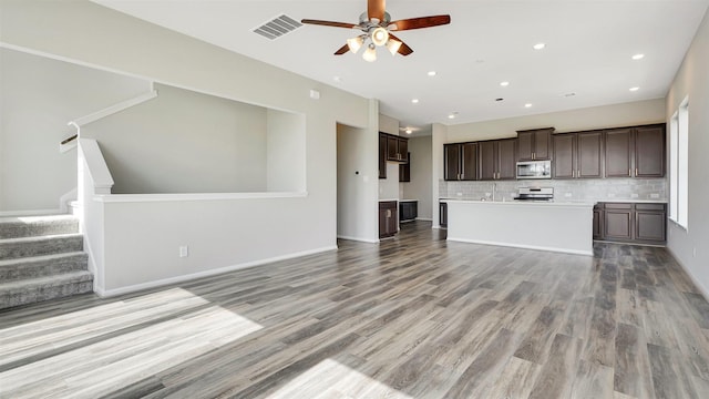 9423 Towne Lake Pkwy, Cypress, TX 77433 - unfurnished living room featuring ceiling fan, light wood-type flooring, stairs, and recessed lighting