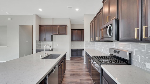 9423 Towne Lake Pkwy, Cypress, TX 77433 - kitchen with appliances with stainless steel finishes, light stone countertops, tasteful backsplash, dark wood-style floors, and dark brown cabinetry