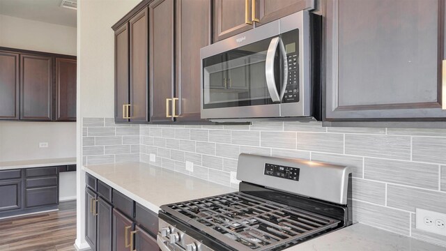 9423 Towne Lake Pkwy, Cypress, TX 77433 - kitchen with stainless steel appliances, decorative backsplash, and wood finished floors