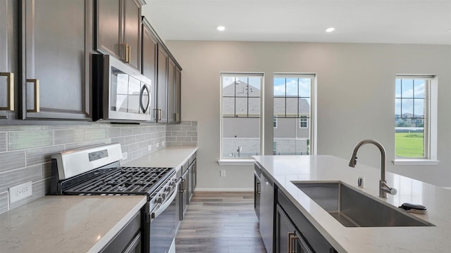 9423 Towne Lake Pkwy, Cypress, TX 77433 - kitchen featuring appliances with stainless steel finishes, healthy amount of natural light, light wood finished floors, dark brown cabinetry, and recessed lighting