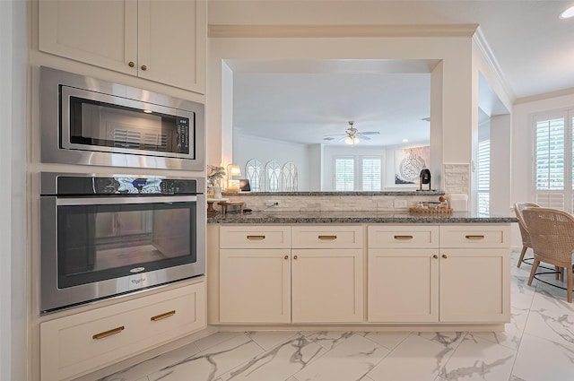 1942 Crisfield Dr, Sugar Land, TX 77479 - kitchen with appliances with stainless steel finishes, crown molding, light marble finish flooring, dark stone counters, and plenty of natural light