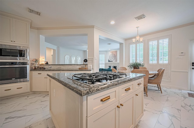 1942 Crisfield Dr, Sugar Land, TX 77479 - kitchen featuring stainless steel appliances, light marble finish flooring, crown molding, a chandelier, and dark stone counters