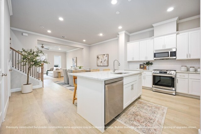 833 Fisher St Unit E, Houston, TX 77018 - kitchen featuring appliances with stainless steel finishes, a sink, open floor plan, recessed lighting, and an island with sink