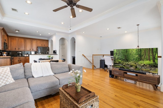 1765 Aden Dr, Houston, TX 77003 - living area featuring a tray ceiling, light wood-style floors, recessed lighting, arched walkways, and ceiling fan