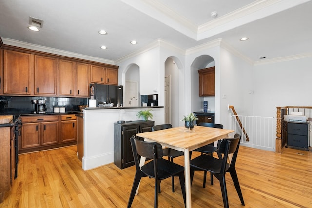 1765 Aden Dr, Houston, TX 77003 - kitchen with freestanding refrigerator, light wood-style flooring, dark countertops, a peninsula, and tasteful backsplash
