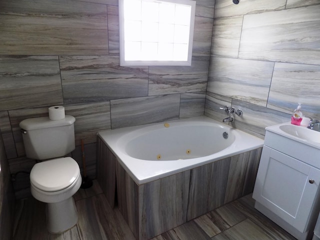688 Blue Water Blvd, Sargent, TX 77414 - full bathroom with toilet, a tub with jets, vanity, and tile walls
