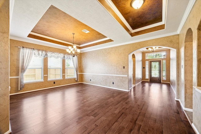22611 Pineleigh Ct, Tomball, TX 77375 - entrance foyer with a chandelier, a tray ceiling, arched walkways, dark wood-style flooring, and ornamental molding
