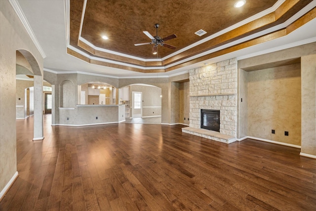 22611 Pineleigh Ct, Tomball, TX 77375 - unfurnished living room with a tray ceiling, ceiling fan, arched walkways, hardwood / wood-style flooring, and ornamental molding