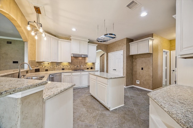22611 Pineleigh Ct, Tomball, TX 77375 - kitchen featuring arched walkways, gas cooktop, light stone countertops, decorative backsplash, and white cabinets