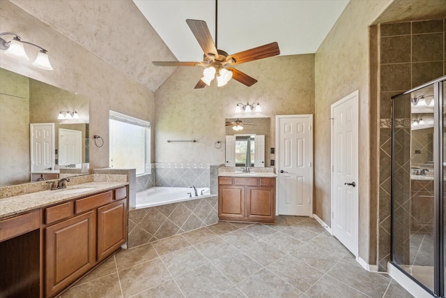22611 Pineleigh Ct, Tomball, TX 77375 - bathroom with plenty of natural light, ceiling fan, two vanities, tile patterned flooring, and vaulted ceiling