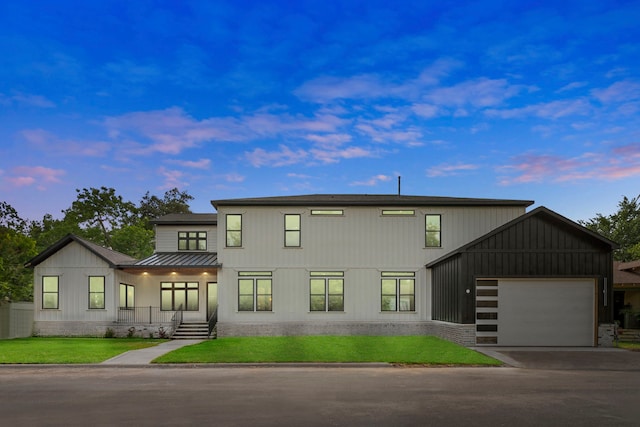 6001 Norhill Blvd, Houston, TX 77009 - view of front of home featuring a garage, driveway, a yard, metal roof, and a standing seam roof